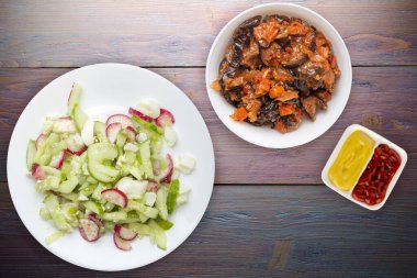 Salatalıklı salata ve mor ahşap arka planda beyaz bir tabakta yumurta. Sağlıklı yiyecekler. Vejetaryen yemeği. Asya mutfağı