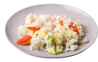 Beyaz arka planda izole edilmiş bir tabakta sebzeli pirinç. Domatesli pilav, salatalık ve soğan. Sağlıklı kahvaltı pirinci.