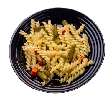 Siyah tabakta sarımsaklı havuçlu yeşil fasulyeli makarna beyaz arka planda izole edilmiş. Akdeniz Mutfağı. sebzeli makarna..