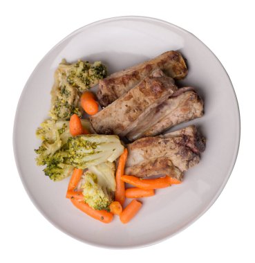 Brokoli lahana, havuç ve sarımsaklı ızgara domuz pirzolası. Beyaz arka planda izole edilmiş sebzeli kızarmış domuz pirzolası. Yürekli kırsal yiyecek üst görünüm