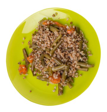 Beyaz arka planda izole edilmiş sarımsaklı ve havuçlu yeşil fasulyeli karabuğday. Yeşil tabakta diyet kahvaltısı. sağlıklı yiyecek vejetaryen üst görünümü