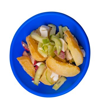 Mavi tabakta sebzeli patates dilimleri beyaz arka planda izole edilmiş. abur cubur Köy yemekleri. Sebzeli patates..