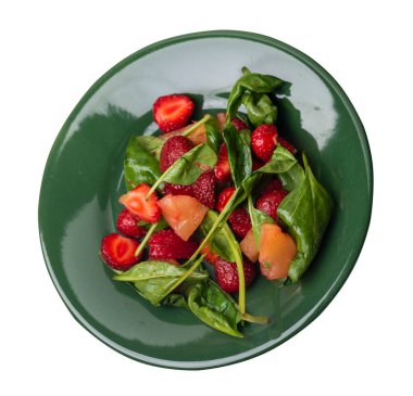 Çilekli salata, ananas ve yeşil tabakta ıspanak. Beyaz arka planda izole edilmiş meyve vejetaryen salatası. Vejetaryen salatası.