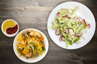 Salatalıklı salata ve siyah ahşap arka planda beyaz bir tabakta yumurta. Sağlıklı yemek. Vejetaryen yemeği. Asya mutfağı
