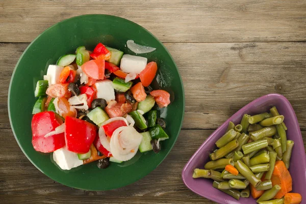 希腊色拉的褐色木制背景 绿色盘子上的希腊色拉 素食色拉顶视图 健康食品 — 图库照片