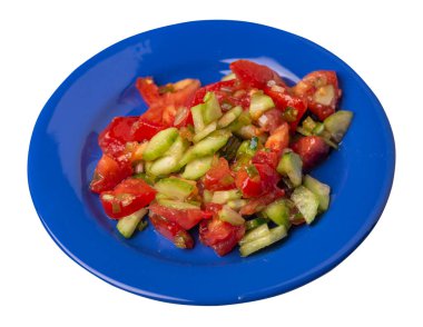 Salatalıklı, domatesli ve yeşil soğanlı vejetaryen salatası. Mavi tabakta, beyaz arka planda izole edilmiş vejetaryen salatası. Sağlıklı sebze kahvaltısı.