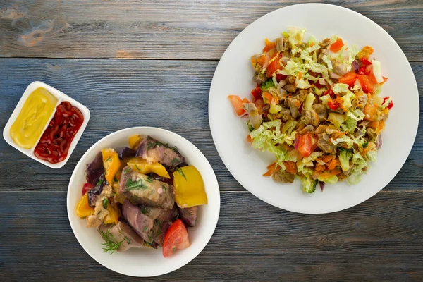 野菜のニンジンと鶏の胃のサラダ 玉ねぎ ピーマン キャベツ トマト ブロッコリー 青い木の背景に白い皿の上にチキンとサラダ — ストック写真