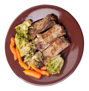 Brokoli lahana, havuç ve sarımsaklı ızgara domuz pirzolası. Beyaz arka planda izole edilmiş sebzeli kızarmış domuz pirzolası. Yürekli kırsal yiyecek üst görünüm