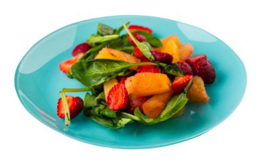 Çilekli salata, ananas ve turkuaz tabakta ıspanak. Beyaz arka planda izole edilmiş meyve vejetaryen salatası. Vejetaryen salatası.