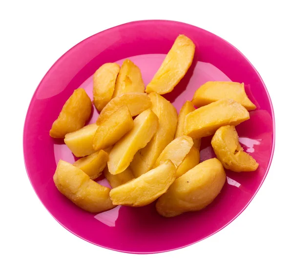 Pembe tabakta kızarmış patates dilimleri. Kızarmış patates sebzeleri beyaz arka planda izole edilmiş. Kırsal yiyecekler üst görünüm