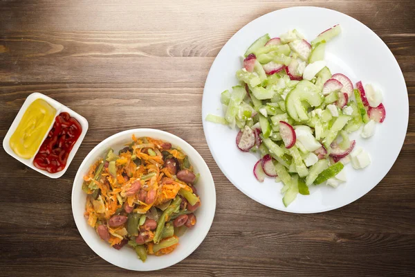 Salatalıklı salata ve kahverengi ahşap arka planda beyaz bir tabakta yumurta. Sağlıklı yemek. Vejetaryen yemeği. Asya mutfağı