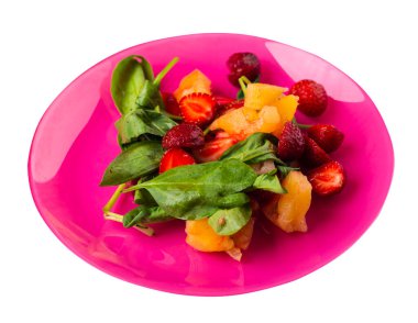 Çilekli salata, ananas ve pembe tabakta ıspanak. Beyaz arka planda izole edilmiş meyve vejetaryen salatası. Vejetaryen salatası.