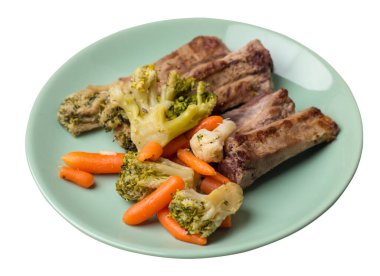 Brokoli lahana, havuç ve sarımsaklı ızgara domuz pirzolası. Beyaz arka planda izole edilmiş sebzeli kızarmış domuz pirzolası. Yürekli kırsal yiyecek üst görünüm