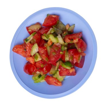 Salatalıklı, domatesli ve yeşil soğanlı vejetaryen salatası. Açık mavi tabakta, beyaz arka planda izole edilmiş vejetaryen salatası. Sağlıklı sebze kahvaltısı.