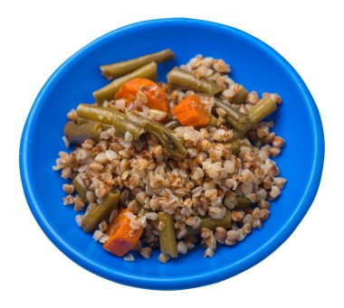 Beyaz arka planda izole edilmiş sarımsaklı ve havuçlu yeşil fasulyeli karabuğday. Yeşil tabakta diyet kahvaltısı. sağlıklı yiyecek vejetaryen üst görünümü