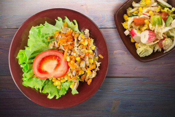 野菜のサラダトップビューと茶色のプレート上にニンジンとトウモロコシとサラダと鶏の胃とサラダ 紫色の木の背景に野菜とチキンサラダ — ストック写真