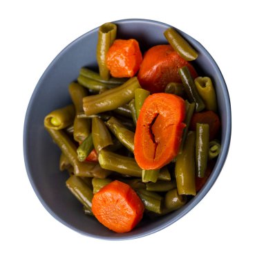 Gri tabakta sarımsaklı ve havuçlu yeşil fasulye. Beyaz arka planda izole edilmiş. Havuç başlıklı yeşil fasulye. sağlıklı vejetaryen yemekleri