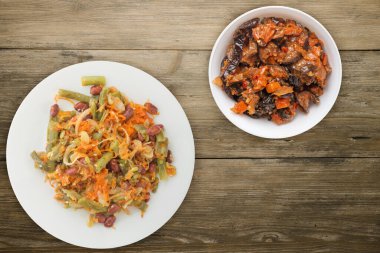 Vejetaryen salata manzarası. Sağlıklı yiyecekler. Fasulye salatası, kuşkonmaz, soğan, havuç ve susam. Tahta bir arka planda beyaz bir tabakta..