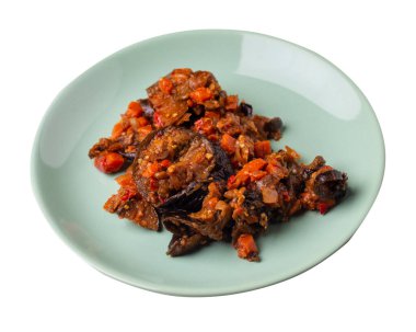 Beyaz arka planda izole edilmiş açık yeşil tabakta domates ve biberli kabak yahnisi. Vejetaryen yemeği. Sağlıklı kahvaltı manzarası