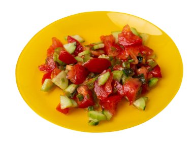 Salatalıklı, domatesli ve yeşil soğanlı vejetaryen salatası. Sarı tabakta, beyaz arka planda izole edilmiş vejetaryen salatası. Sağlıklı sebze kahvaltısı.