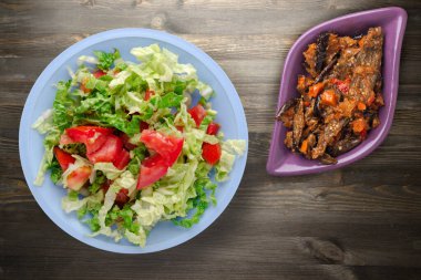 Vejetaryen yemeği. Siyah ahşap arka planda lahanalı domates salatası. sağlıklı yiyecekler