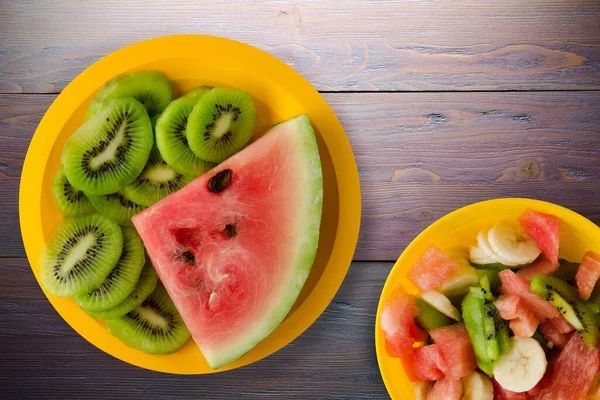 Watermeloen Kiwi Gesneden Een Gele Plaat Een Paarse Houten Achtergrond — Stockfoto