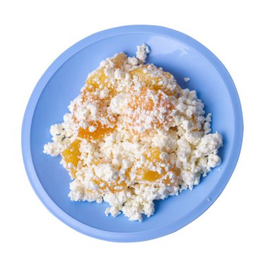 Açık mavi tabakta şeftalili süzme peynir beyaz arka planda izole edilmiş. Süzme peynirin üst tarafı. sağlıklı kahvaltı