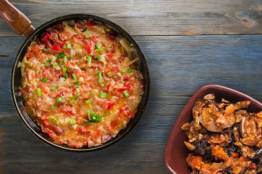 Gri mavi ahşap arka planda soğanlı haşlanmış domatesler. Metal tepsi manzaralı soğanlı haşlanmış domates. Vejetaryen yemeği.