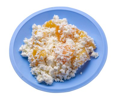 Açık mavi tabakta şeftalili süzme peynir beyaz arka planda izole edilmiş. Süzme peynirin üst tarafı. sağlıklı kahvaltı