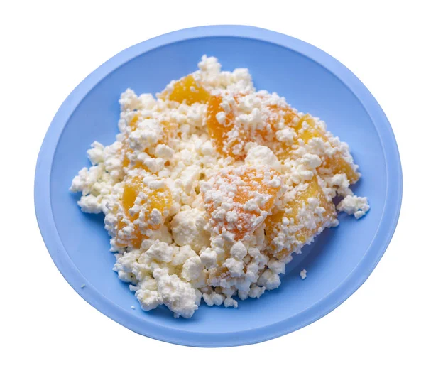 Açık mavi tabakta şeftalili süzme peynir beyaz arka planda izole edilmiş. Süzme peynirin üst tarafı. sağlıklı kahvaltı