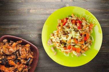 Tavuk mideli salata ile sebze havuç, soğan, biber, lahana, domates, brokoli. Limonlu tavuklu salata, siyah ahşap arka plan manzaralı.