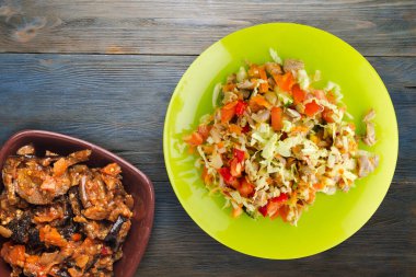 Tavuk mideli salata ile sebze havuç, soğan, biber, lahana, domates, brokoli. Sarı tabakta tavuklu salata. Mavi ahşap arka planda. Vejetaryen yemeği.