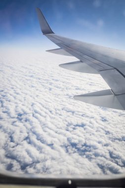 Beyaz bulutların üzerinde güzel mavi bir gökyüzü ile bir uçak yolculuğuna çıkmak