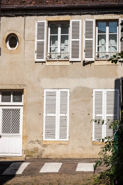 Alte Hausfassade mit Rollladen und weißer Tür — Stockfoto