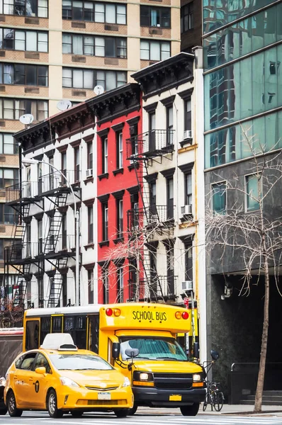 Manhattan sokaklarında okul otobüsü ve sarı taksi