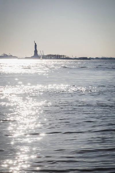 Статуя Свободы против света из нижней части Манхэттена — стоковое фото