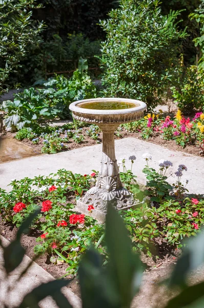 Fountain of a classic flower garden of a Parisian course in Paris