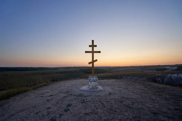 Wooden orthodox cross on the top of Golgotha mountain in the Kostomarovo St. Saviour Monastery at sunset.