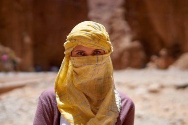 Portrait of the female tourist with a tied yellow berber tagelmust scarf.          clipart