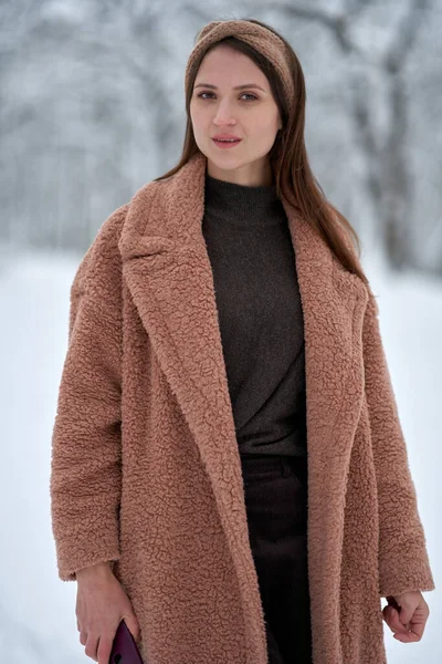 冬の森の中のベージュのコートの美しい女性の肖像画 — ストック写真