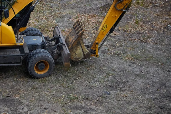 Stacked excavator bucket after construction work against the background of a soil plot, mockup, completion of construction, close-up of the excavator bucket.