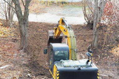 Top view of an excavator digging a trench for laying utilities.