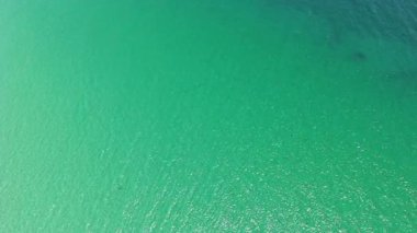 Deniz suyu yüzeyi. Okyanusun dalgalı suyu. Aquamarine okyanus doğası. Temiz turkuaz deniz suyunun arka planı. Idyllic yaz tatili. Karayip Denizi. Hava görüntüsü. Dalgalı yüzey.