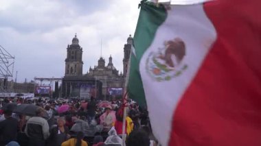 MEXICO Şehri, 01 / 07 / 19. Meksika bayrağı dalgalanırken, Başkan Lopez Obrador ve Morena partisinin destekçileri başkanın seçimlerdeki galibiyetinin birinci yılını kutlamak için konuşmasını bekliyorlar. Çekim 1