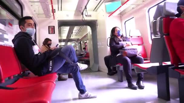Menschen fahren im Zug mit Mundschutz — Stockvideo