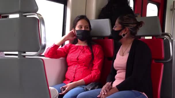 İki kadın banliyö treninde maske takarak seyahat ediyor. — Stok video