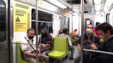 Yüz maskesi takan bazı insanlar metroda seyahat eder.