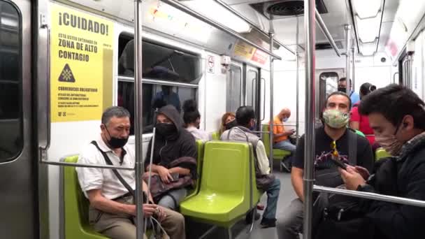 Alcune persone che indossano maschere facciali viaggiano in metropolitana — Video Stock