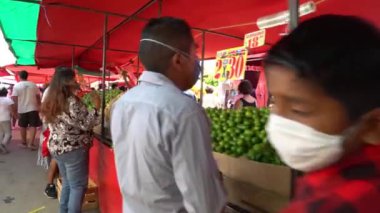 Meksiko şehri, Meksiko. Temmuz 2020. Yerel yetkililerin COVID-19 ile ilgili tedbirleri azaltmasının ardından, insanlar yürür, alışveriş yapar ve sokak pazarındaki havanın tadını çıkarırlar. Bazıları yüz maskesi takar, bazıları takmaz.