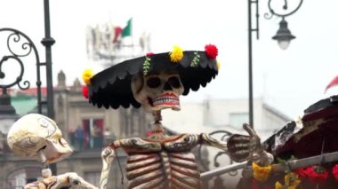 Mexico City, Kasım 2019. Mexico City 'de Ölüm Günü sırasında şapkalı ve çiçekli dev bir karton iskelet kukla gösteriliyor..